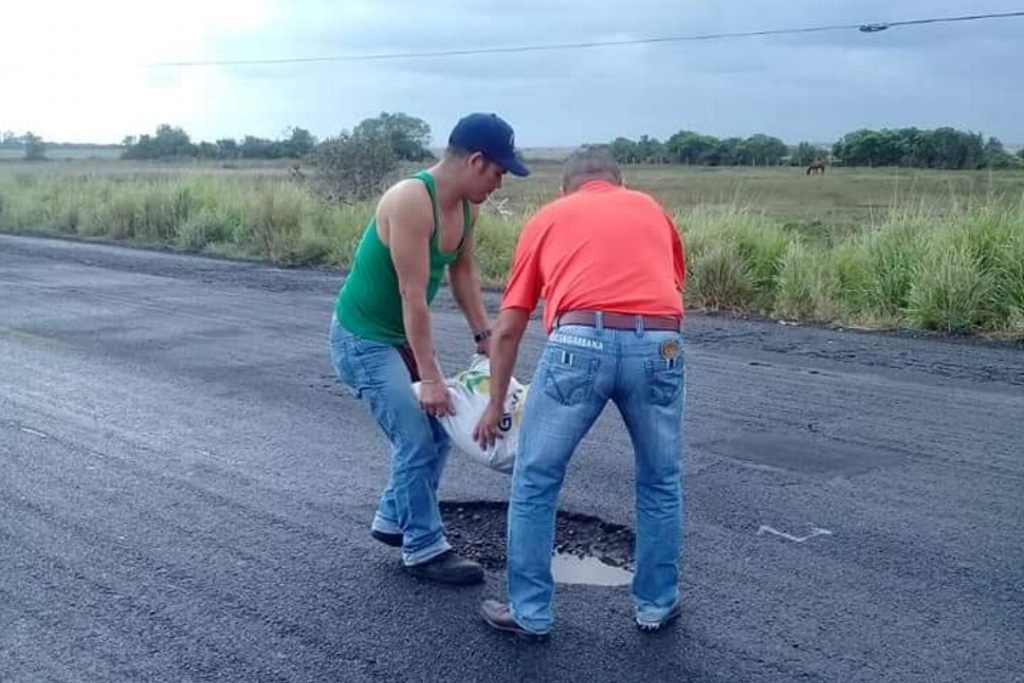 Imagen Empresarios rellenan baches con costales de arena en carretera de Veracruz (+Fotos)