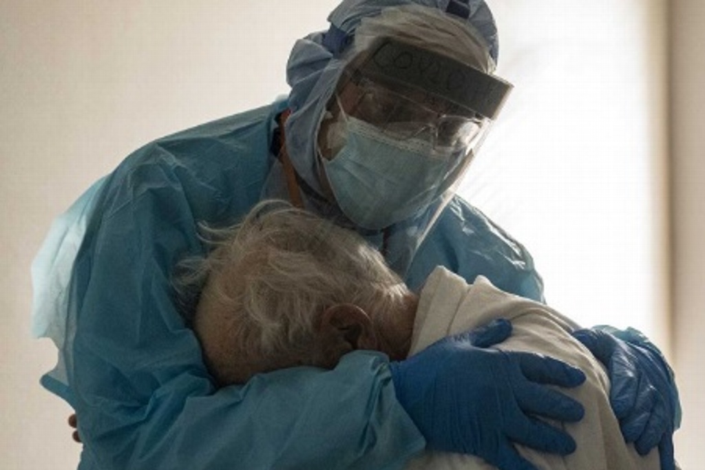 Imagen Conmueven doctor y paciente de COVID-19 llorando, abrazados