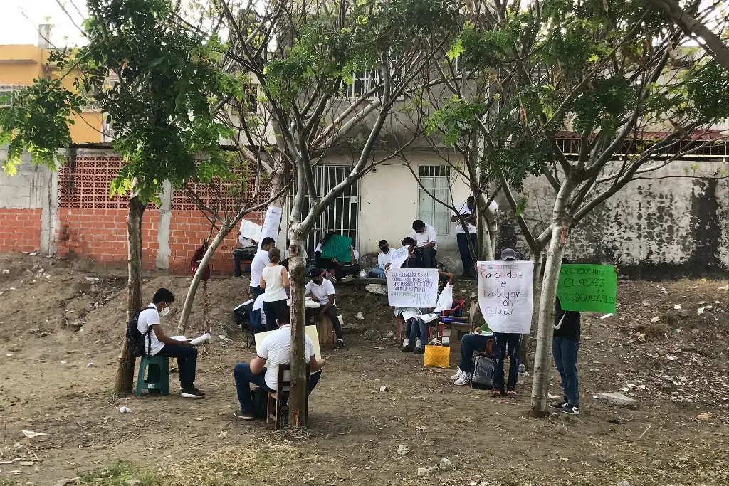 Bajo los árboles y con el fuerte calor, estudiantes de telesecundaria toman clases en Veracruz