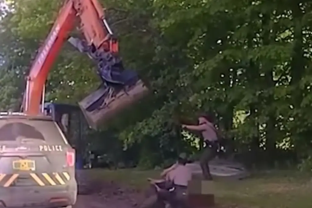Imagen Hombre ataca a policías con una excavadora para impedir que arresten a su hijo (+video)