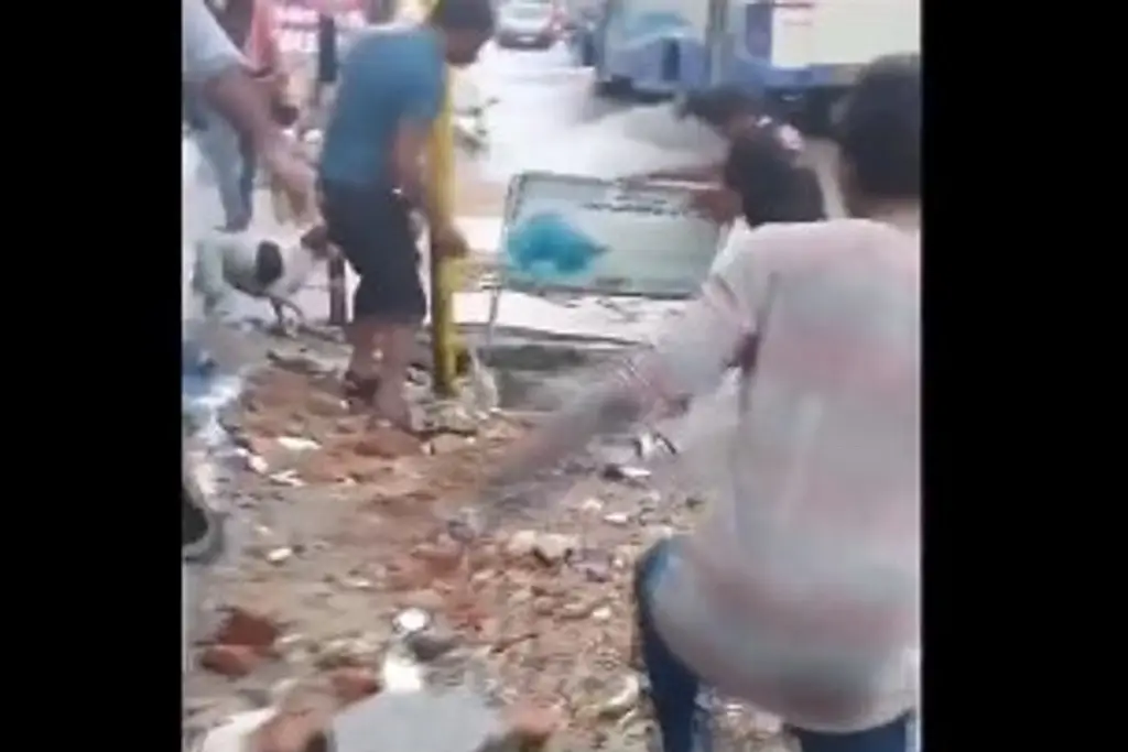 Imagen Cruza calle inundada y cae por la coladera (+Video)