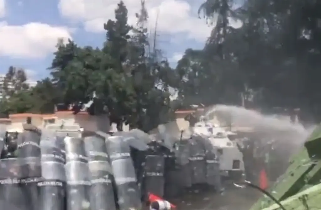 Imagen Con tanqueta y agua, militares dispersan a normalistas que protestan en Campo Militar 1