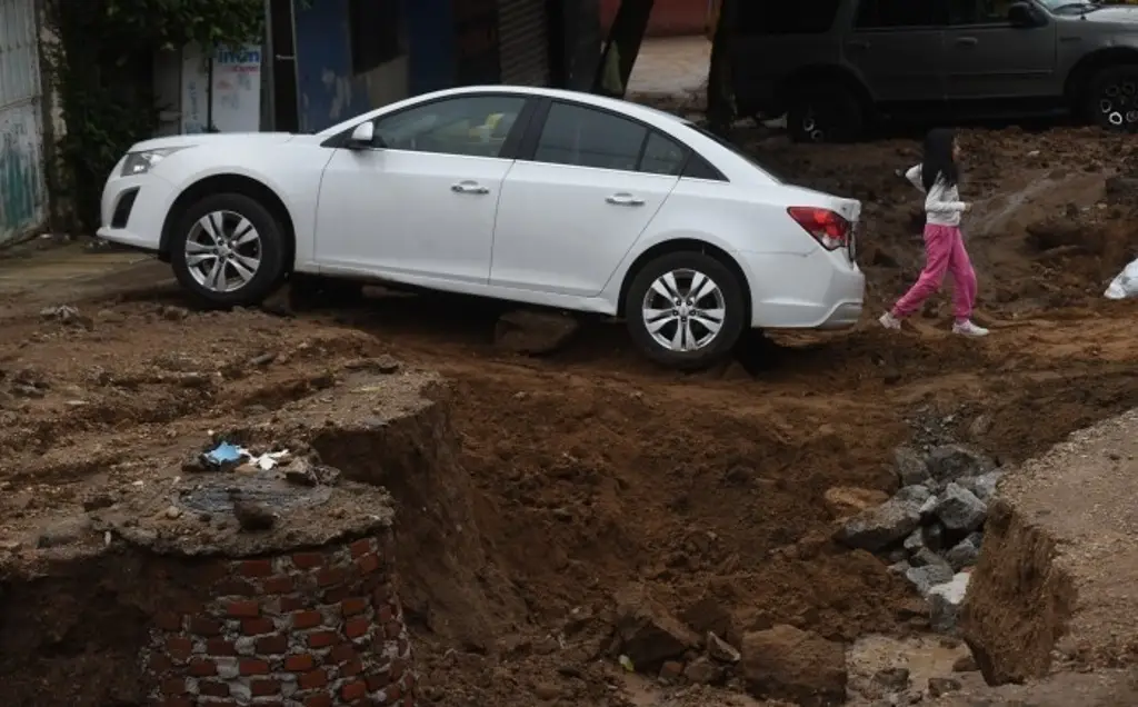 Imagen Se hunden 2 autos en socavón de calle; vecinos culpan a las autoridades