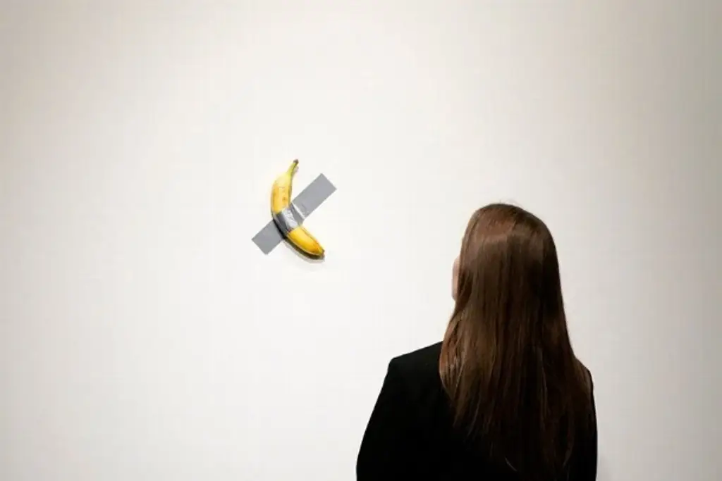 Imagen Visitante 'se come' la obra 'Comedian', famoso plátano pegado con cinta en la pared