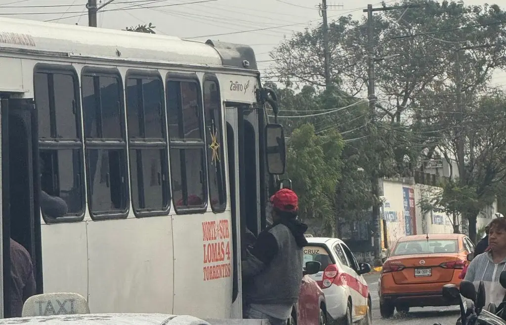 Imagen Pocos camiones y los que pasan van con pasajeros colgando en estribo; los taxis hacen su agosto