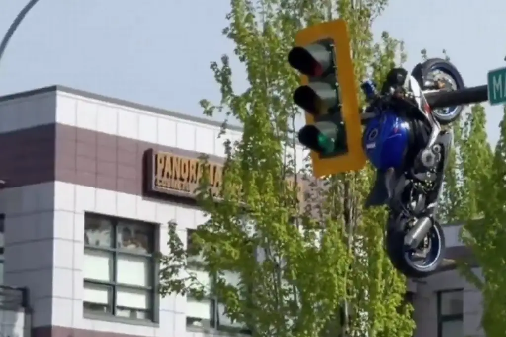 Imagen Moto termina colgada de semáforo tras chocar contra auto (+Video)