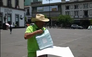 Imagen Profesor bebe gasolina como protesta en Xalapa; amaga con inmolarse 