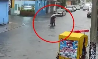 Imagen Cae en registro sin tapa en calle inundada por lluvia, en el Estado de México