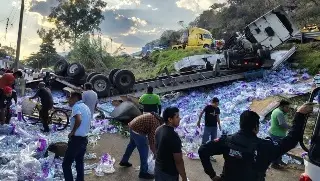 Vuelca tráiler con 60 toneladas de agua embotellada en autopista de Veracruz; realizan rapiña 