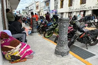 Pasan la noche en la banqueta, con todo y viento del norte, para sacar placas en Veracruz