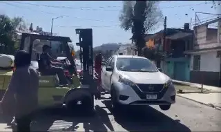 Con montacargas, taller quita autos 'mal estacionados' en Xalapa 