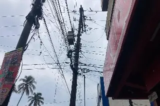 Comerciantes de Veracruz reportan poste de CFE apunto de caer; llevan varias horas sin luz